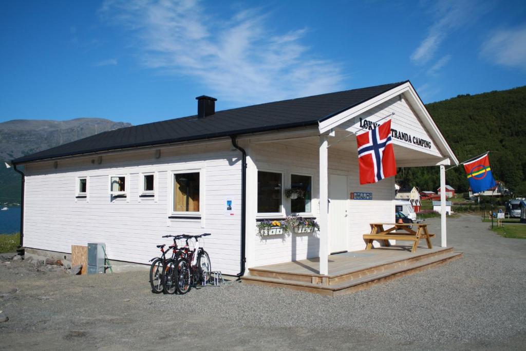 SamuelsbergLøkvollstranda camping As的一座白色的建筑,外面有自行车停放