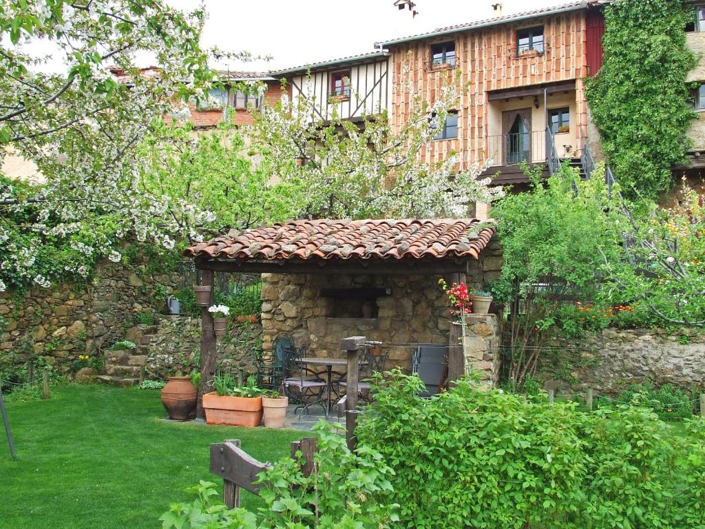 Villanueva del CondeCasas rurales Caño Chico y La Fuente的花园设有石头建筑和庭院