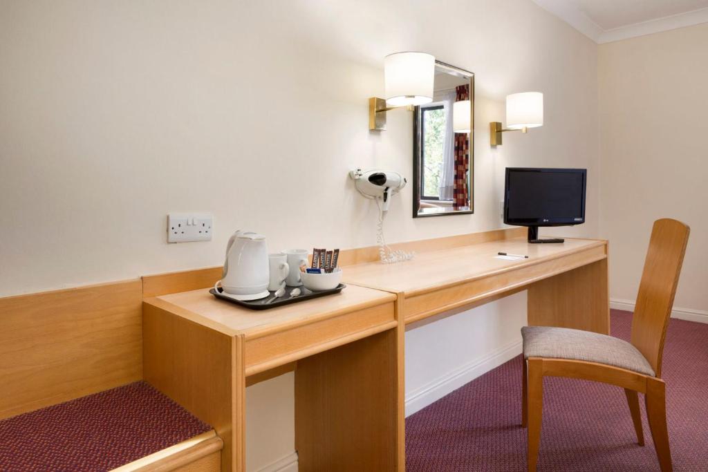 Strensham图克斯伯里戴斯酒店的客房设有带电话的书桌和电视。