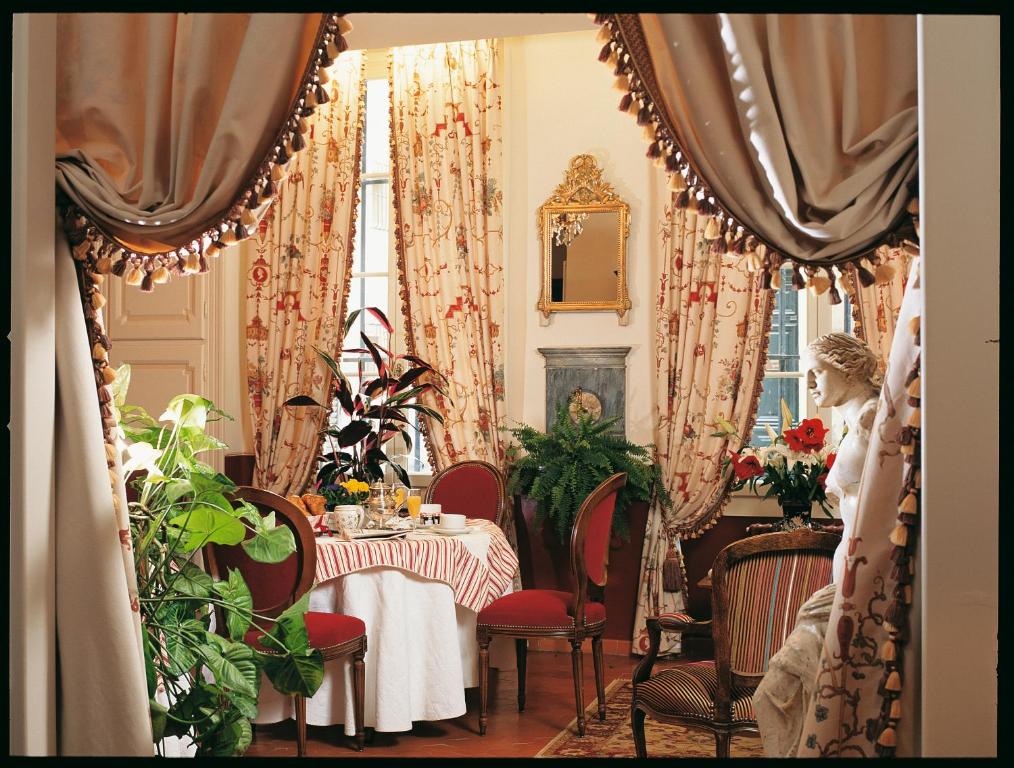 普罗旺斯艾克斯Hotel Cardinal的一间带桌椅和窗帘的用餐室