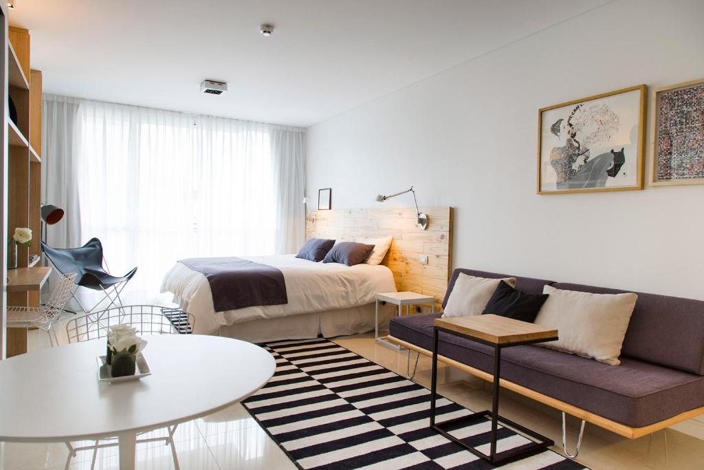 布宜诺斯艾利斯Lemon Suites的一间卧室配有一张床、一张沙发和一张桌子