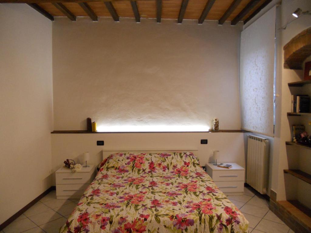 比森齐奥营Luigi Home的一间卧室配有一张带花卉床罩的床