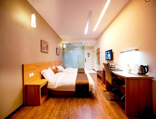 扬州尚客优连锁江苏扬州邵伯大运河店的酒店客房配有一张床、一张书桌和一张书桌。