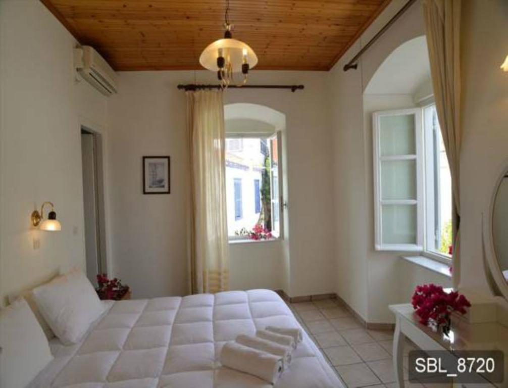 伊兹拉Areti的卧室设有一张白色大床和两个窗户。