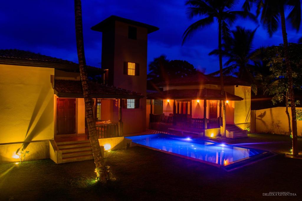 高尔Breeze Villa Unawatuna的一座晚上设有游泳池的房子