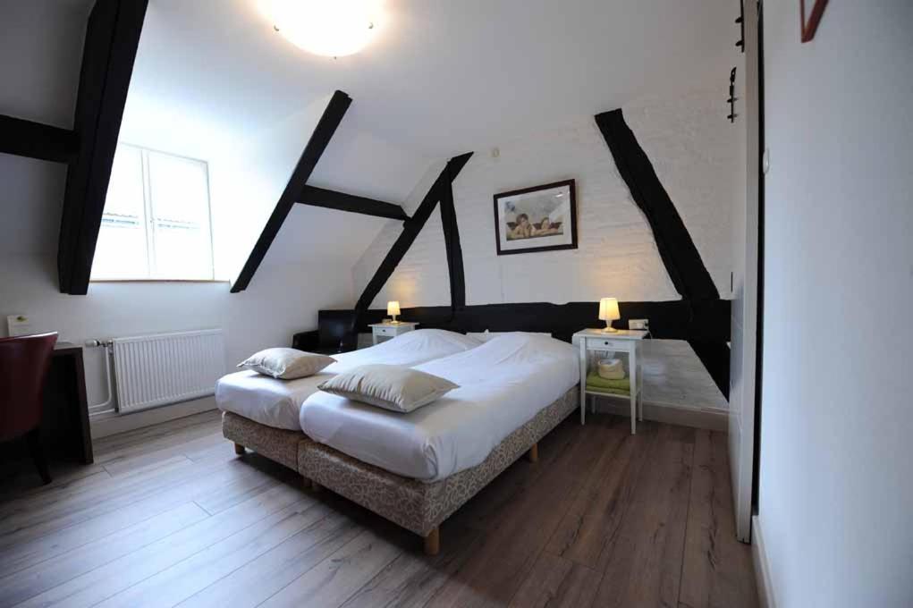 梅赫伦Hotel De Oude Brouwerij的一间卧室设有一张大床和一个大窗户