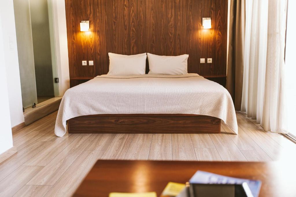 阿基欧斯尼古拉斯杜拉克酒店的一间卧室设有一张带木墙的大床