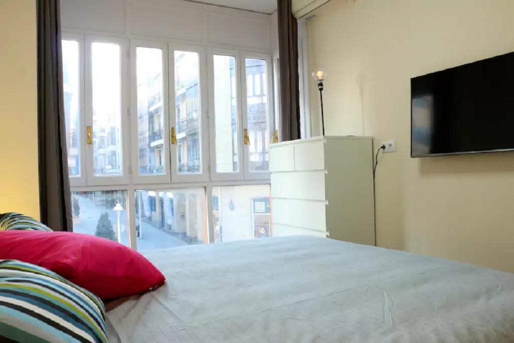 毕尔巴鄂Apartamento Villarias的一间卧室设有一张床和一个大窗户