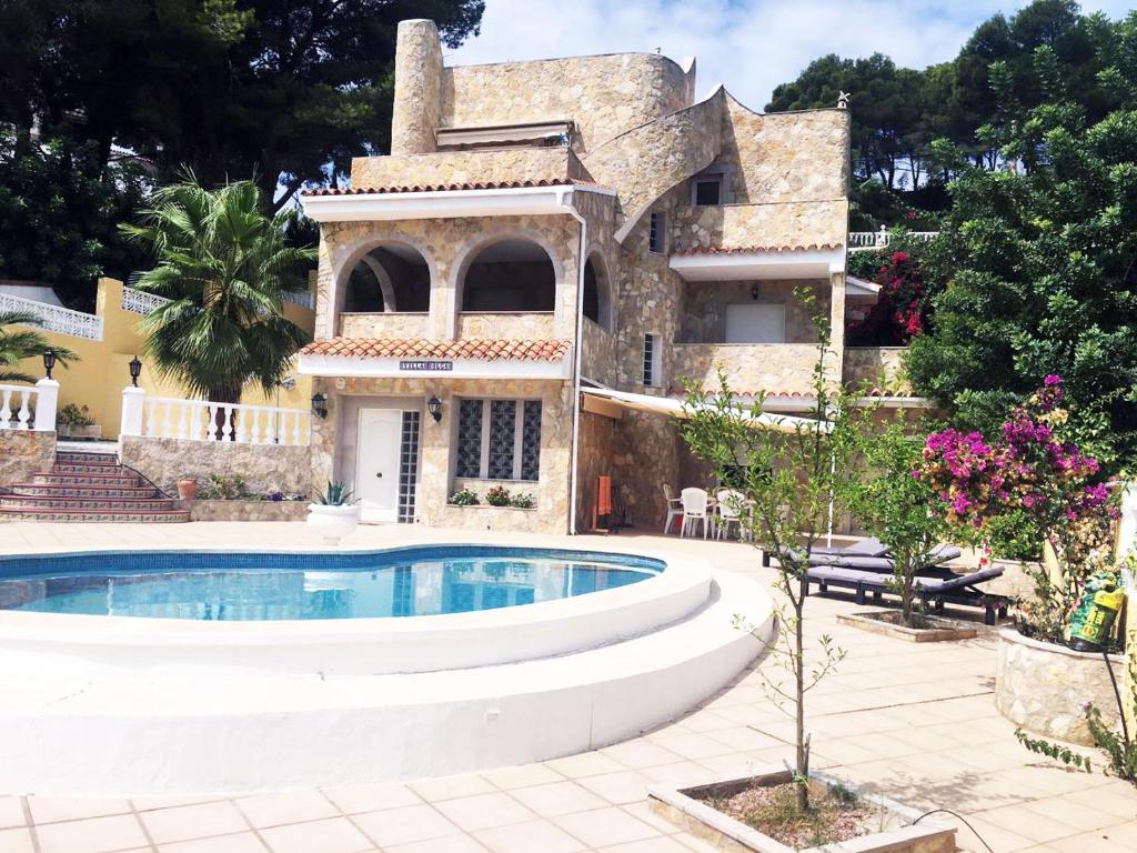 奥罗佩萨德尔马Villa con piscina的一座房子前面设有游泳池