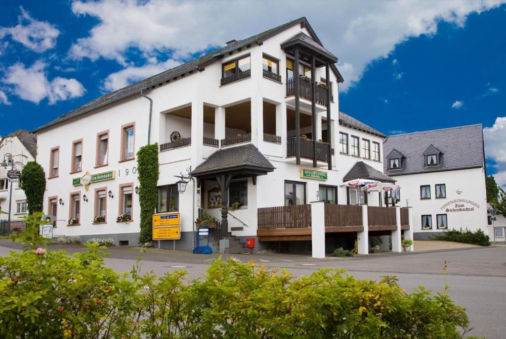 Strotzbüsch西本巴赫塔尔乡村旅馆的街道上一座大型白色建筑,设有阳台