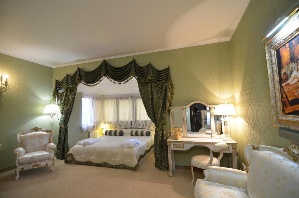 MylaCitadel Hotel的卧室配有一张床和一张桌子及椅子