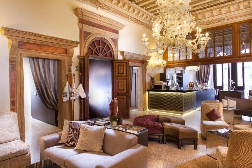 威尼斯阿卡迪亚精品酒店的客厅配有家具和吊灯。