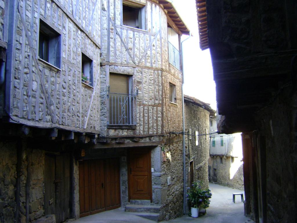 圣马尔廷德尔卡斯塔尼亚尔Casa Lopez的一条拥有古老石头建筑和木门的小巷