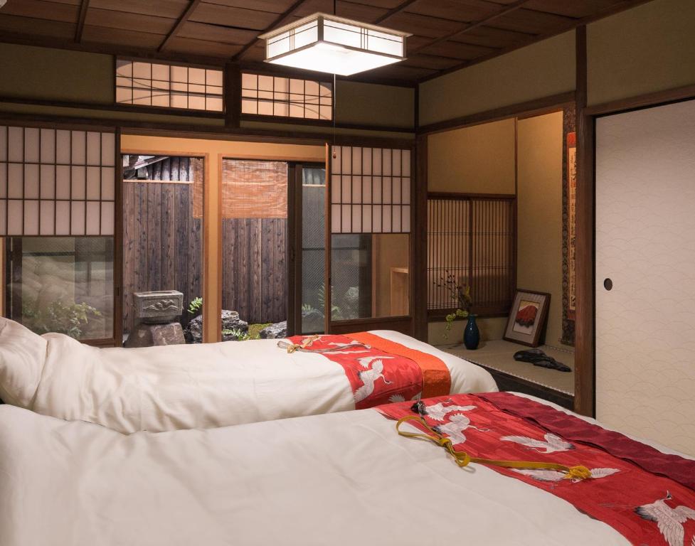 京都丸子旅馆京都酒店的带窗户的客房内的两张床