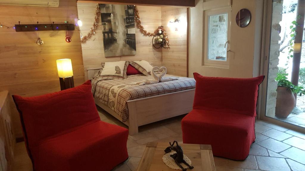 瓦隆蓬达克奥利维尔的玛莎妈妈酒店的一间卧室配有一张床和两张红色椅子