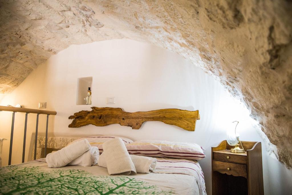 奥斯图尼Il Nido Bianco的卧室配有一张挂在墙上的木床