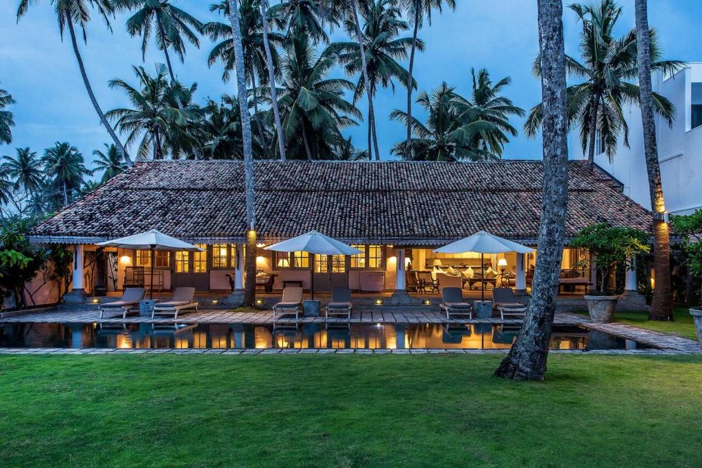 哈巴拉杜瓦萨穆德拉海滨别墅的一个带游泳池、椅子和棕榈树的度假村
