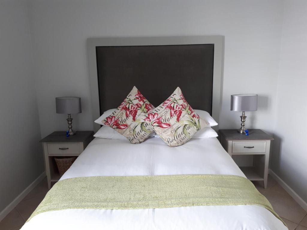 乔治51 Trafford的卧室配有带4个枕头的白色床