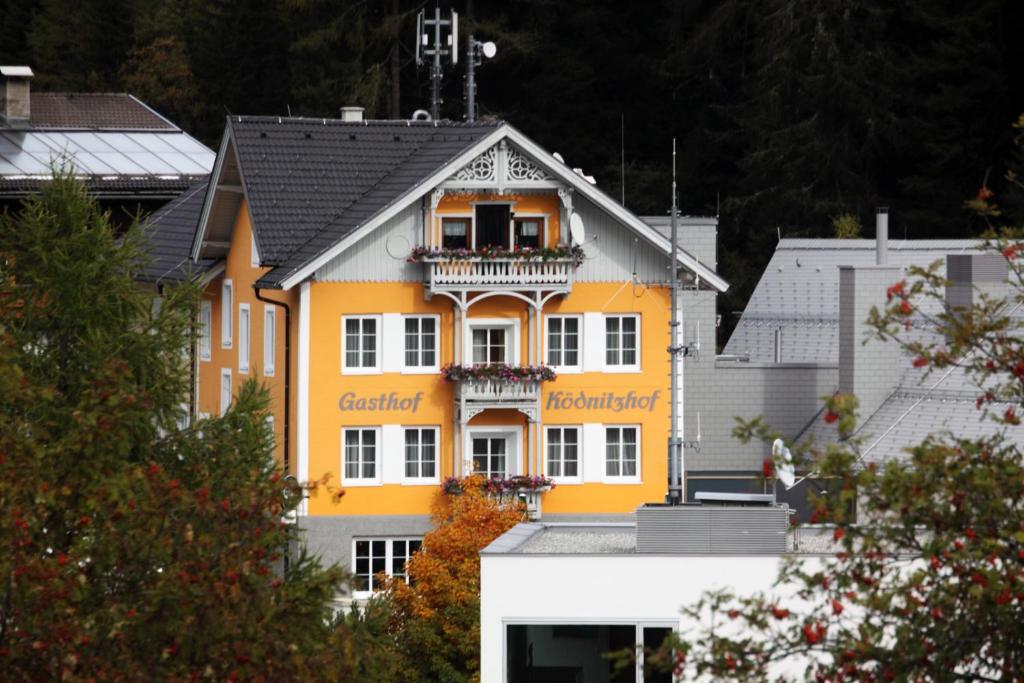 大格洛克纳山麓卡尔斯柯德尼茨霍夫酒店的黄色的建筑,上面设有阳台