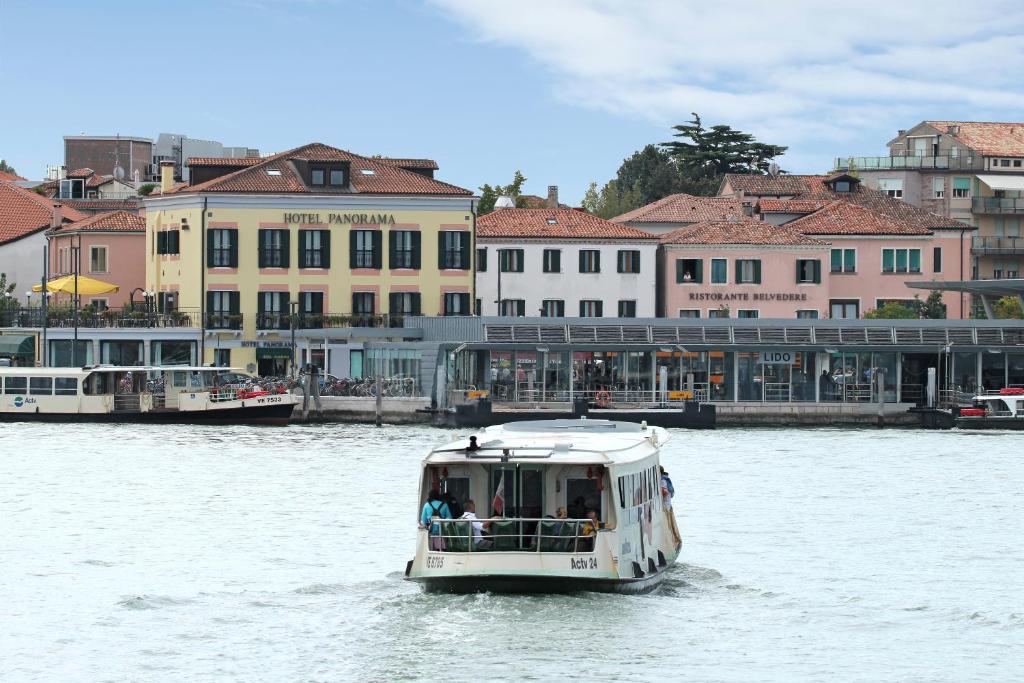 威尼斯丽都全景酒店的建筑物前水面上的白色船