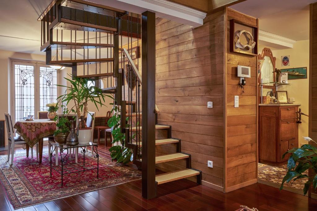 翁弗勒尔穆加多尔公寓的一间带螺旋楼梯的客厅和一间用餐室