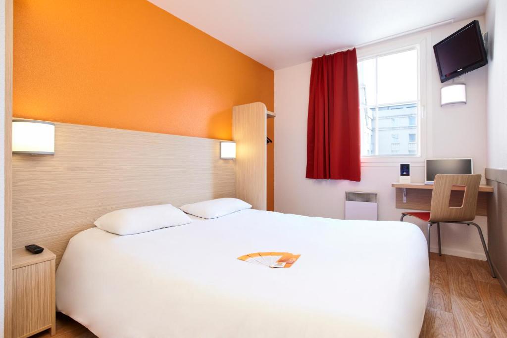 尚布雷莱图尔南图尔 - 图尔钱布雷布普瑞米尔经典酒店的卧室配有一张白色大床和一张书桌