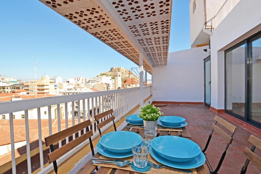 阿利坎特Atico Colón 21的阳台配有蓝色的桌椅,享有风景。