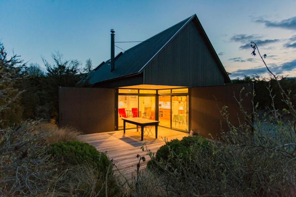 特卡波湖The Black House with Stunning Outdoor Bath的前面有一张野餐桌的房子