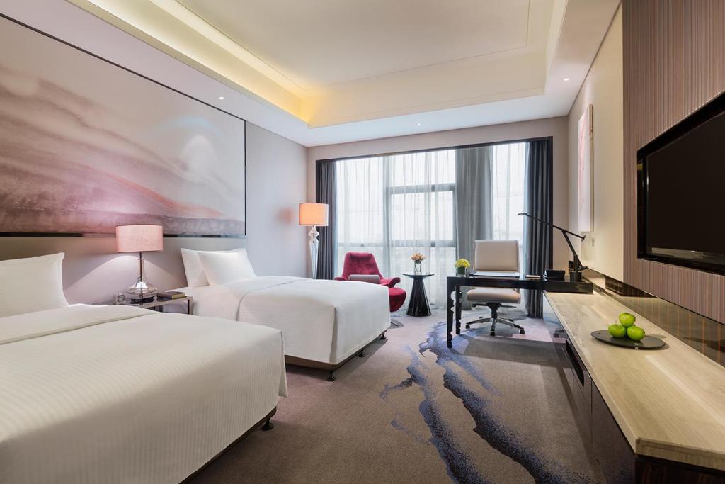 武汉武汉富力万达嘉华酒店的酒店客房设有两张床和一台平面电视。