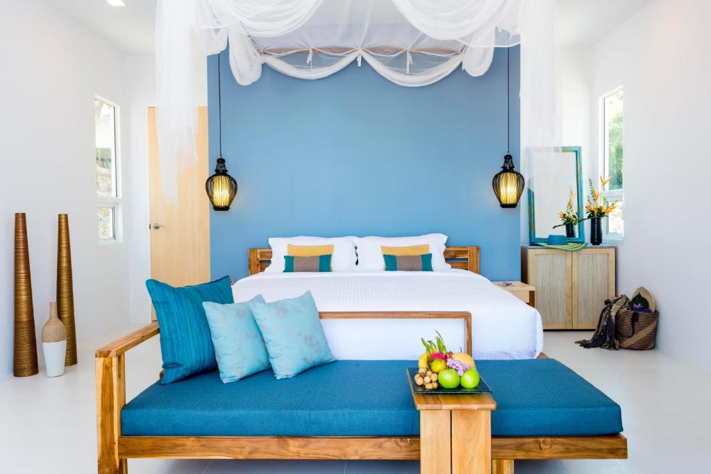 塔可克海滩甲米之家度假酒店的一间卧室设有一张床和蓝色的墙壁