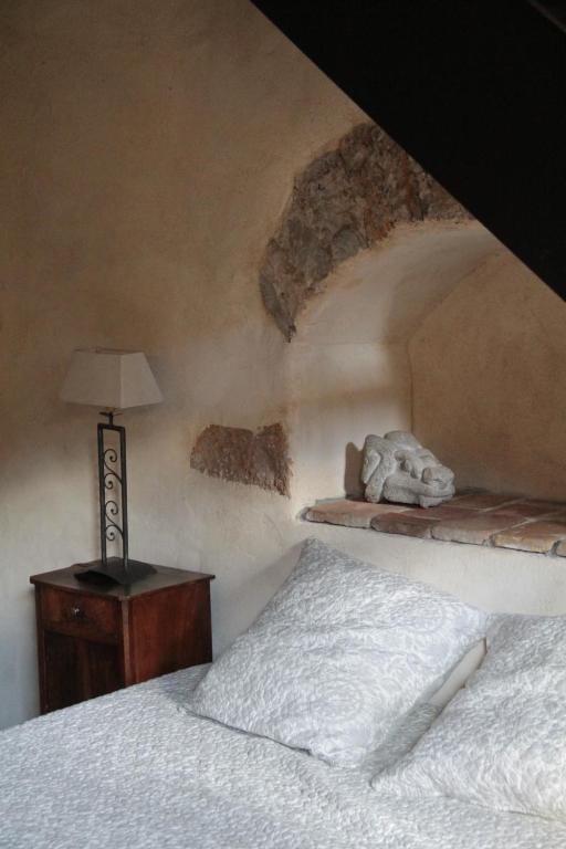 里昂圣约斯特拉特利尔旅馆的一间卧室配有一张床和一张带台灯的桌子