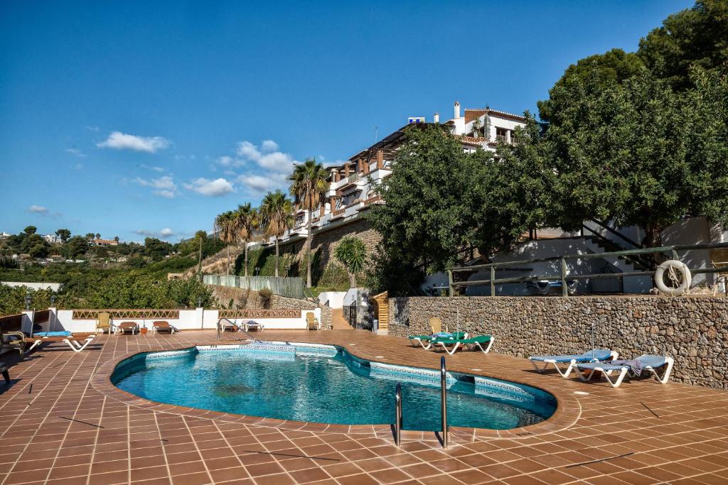 弗里希利亚纳阿尔玛扎拉乡村酒店的一个带椅子的游泳池和一个背景建筑