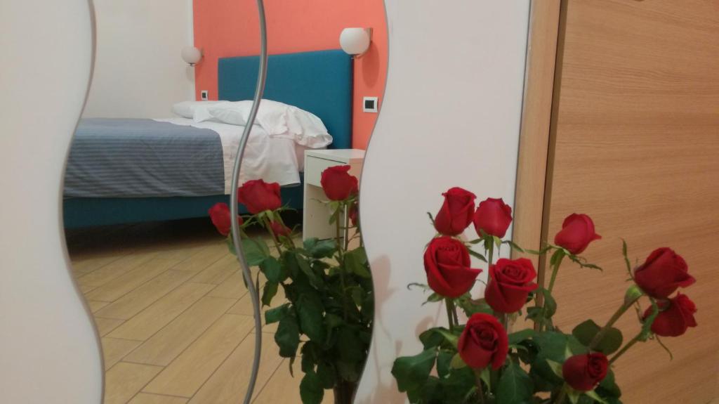 那不勒斯玻薇欧套房酒店的有一束红玫瑰,在一间有床的房间