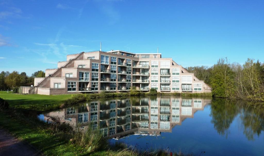 布林瑟姆Golf-Resort Brunssummerheide的靠近水体的大建筑