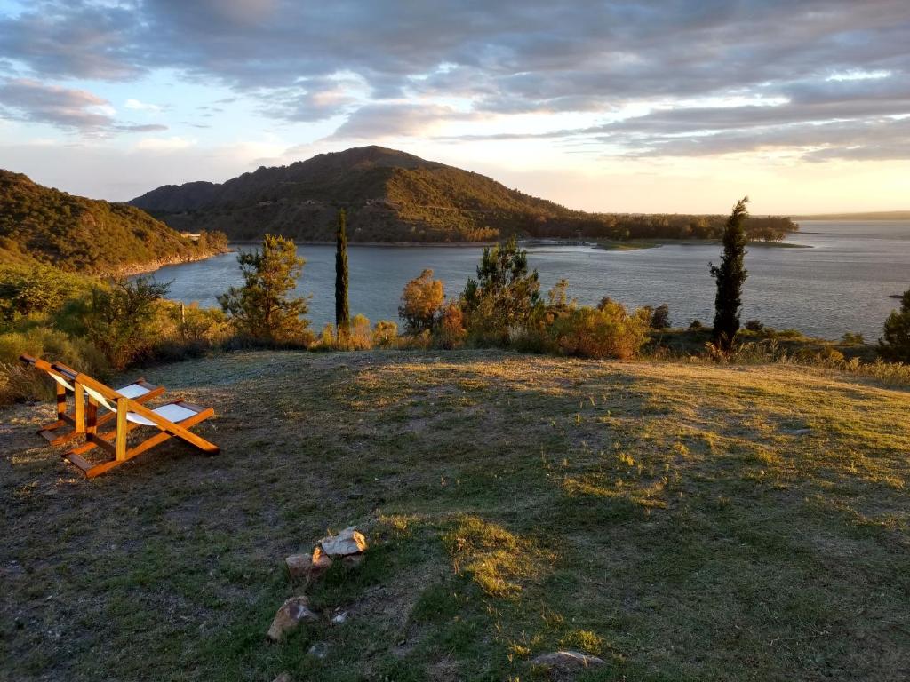 美国别墅城Peperina Lago Los Molinos的坐在湖旁田野顶上的长凳