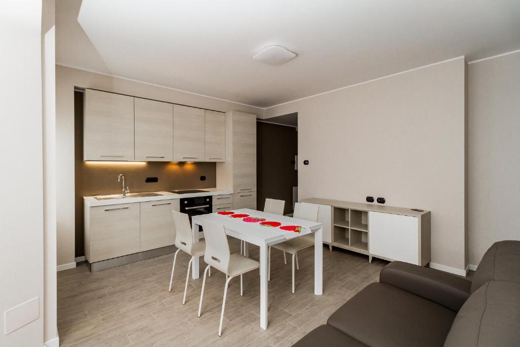 莱科Lake Como Apartments的厨房以及带白色桌椅的用餐室。