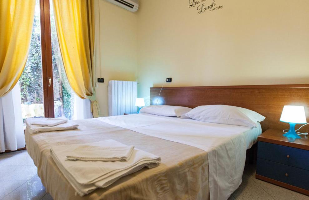 米兰格雷科酒店的一间卧室配有一张大床和毛巾