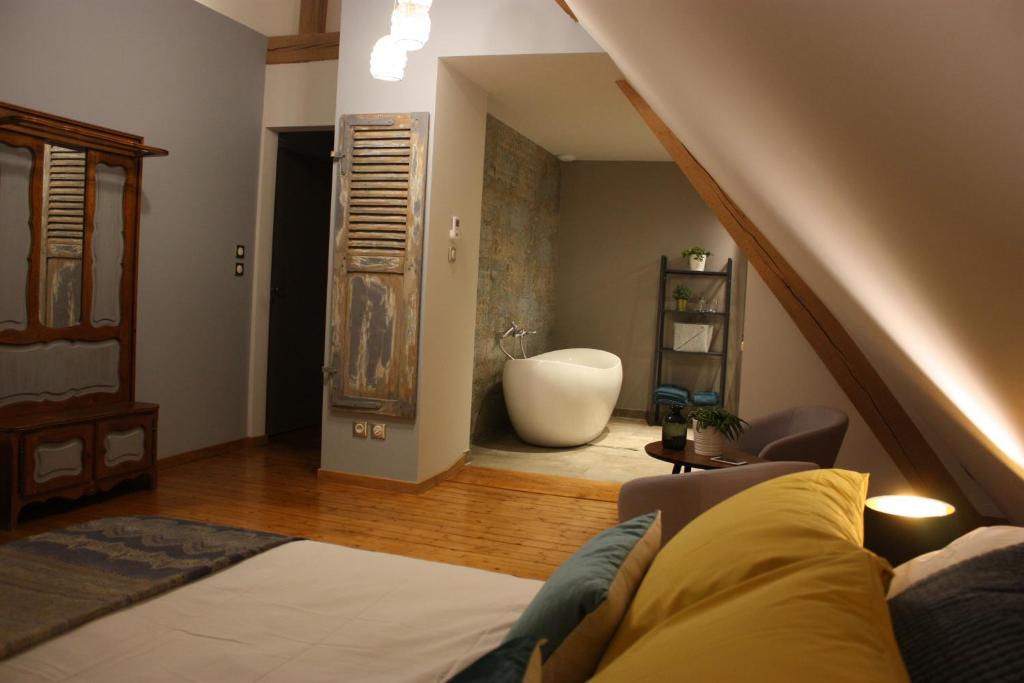 塞尔奈Théière & Couverts - Les Chambres的一间带床和浴缸的客厅