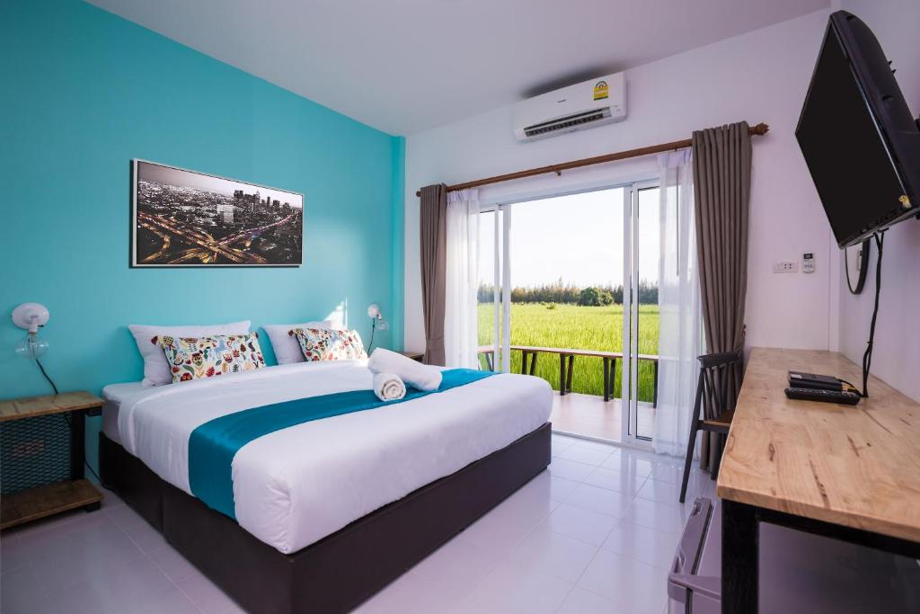 武里南Xaiyong Resort - ไทรโยงรีสอร์ท的一间卧室设有一张床、一台电视和一个窗口。