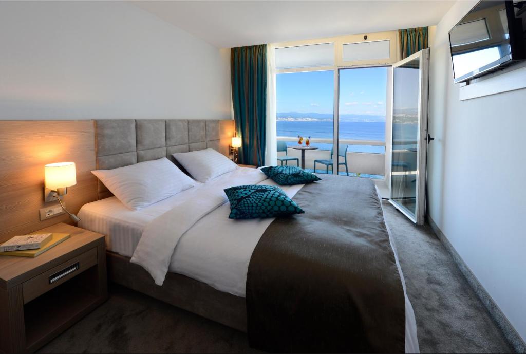 奥帕提亚亚得里亚海2号大酒店的一间卧室设有一张大床,享有海景