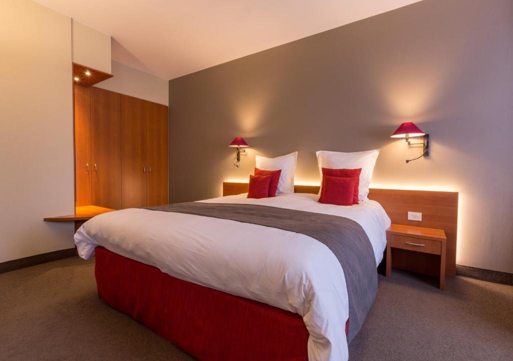 德帕内Hotel Royal的酒店客房配有一张带红色枕头的大床