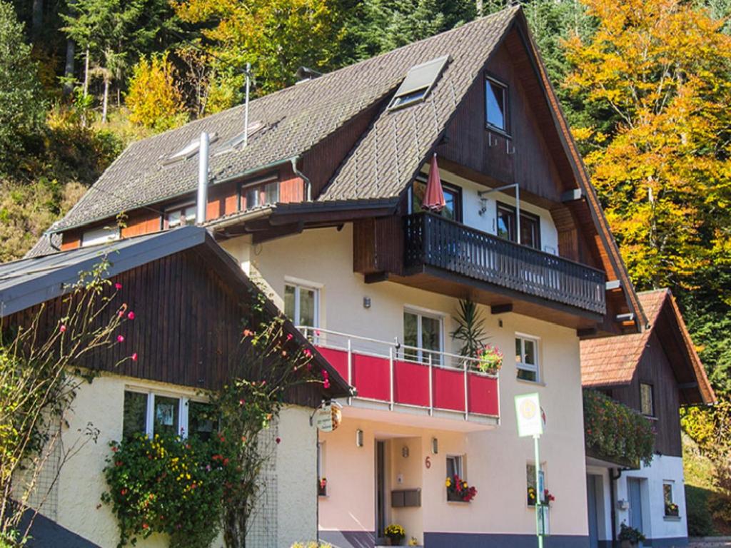 奥佩瑙Ferienwohnung am Hauskopf的一座大房子,设有红色的阳台和树木