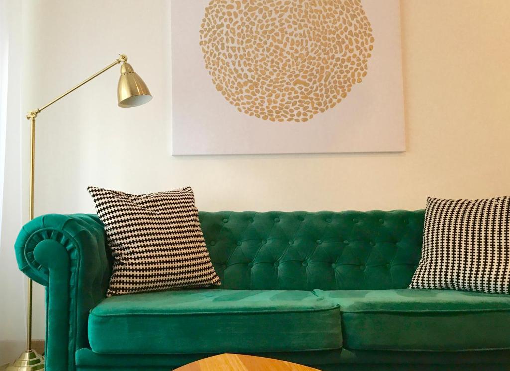 利耶帕亚Design apartment的客厅里绿沙发与灯