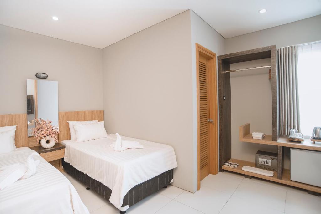万隆Mogens Guesthouse的酒店客房设有两张床和窗户。