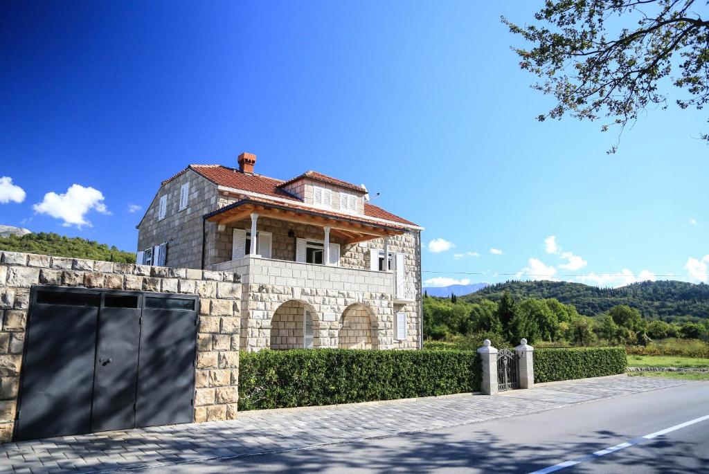 格鲁达Apartment Dubrovnik Banac的车道前有车库的建筑