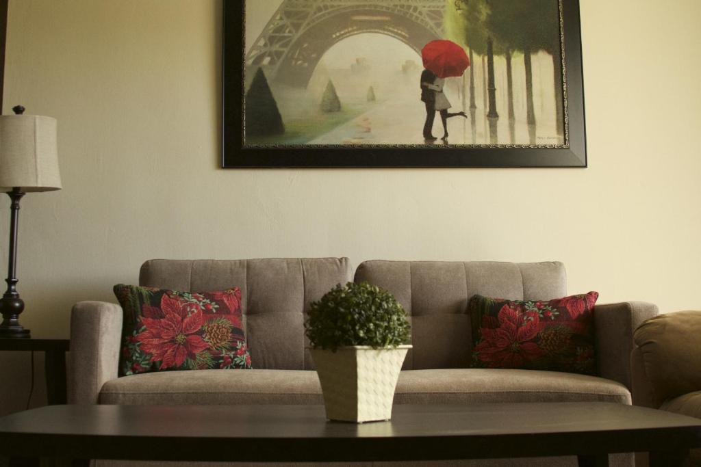 Mangilao代佩德罗之家别墅的客厅配有沙发,客厅配有一张带雨伞的女人的照片