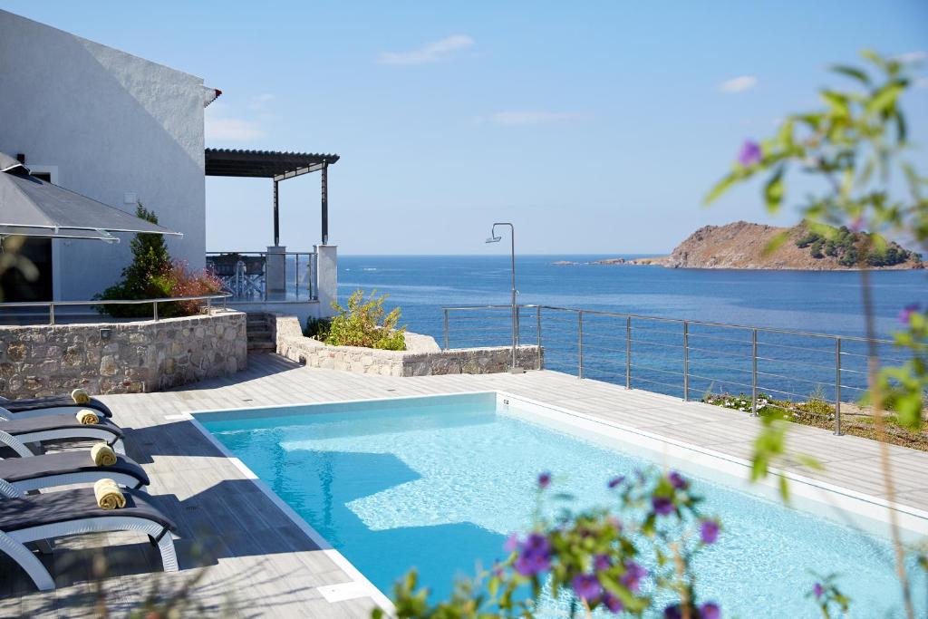 帕特雷Eleia Seafront Rooms & Villas的一个带椅子的游泳池,享有海景