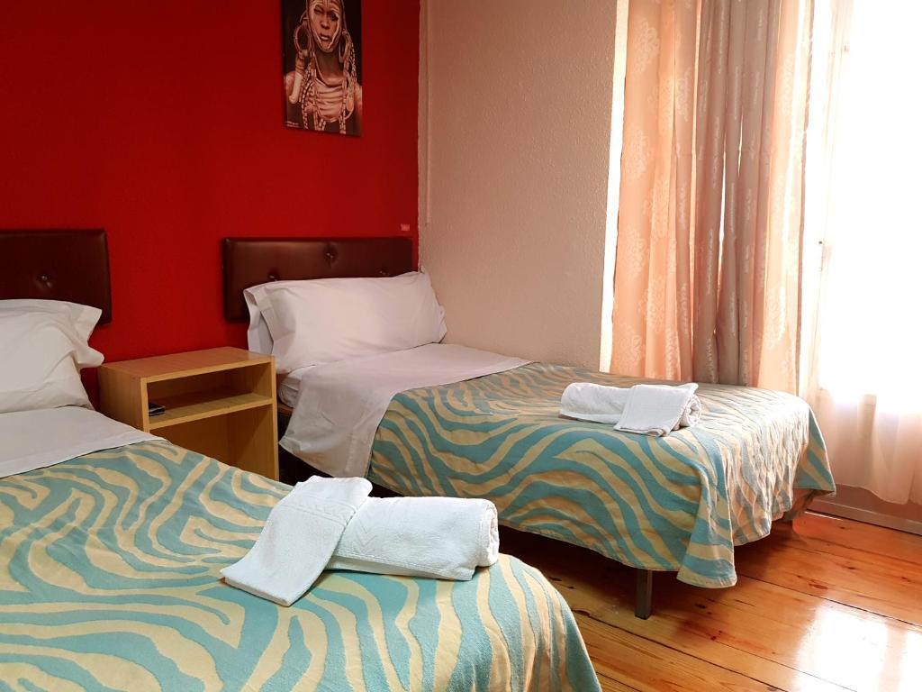 莱昂Hostal Padre Isla 1的一间设有两张床铺和毛巾的房间