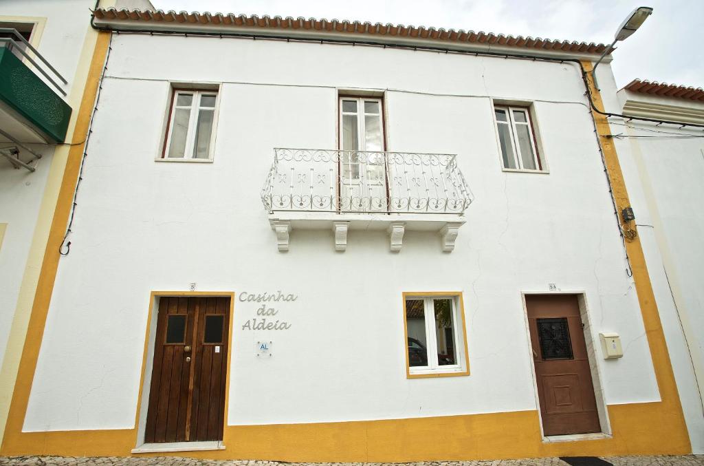 梅利迪什Casinha da Aldeia的白色房子的一侧设有阳台