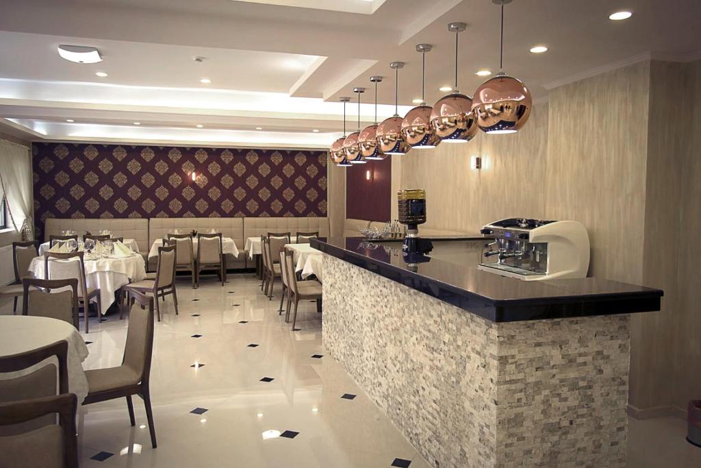 雅西Hotel Terra Iasi的餐厅设有酒吧,配有桌椅